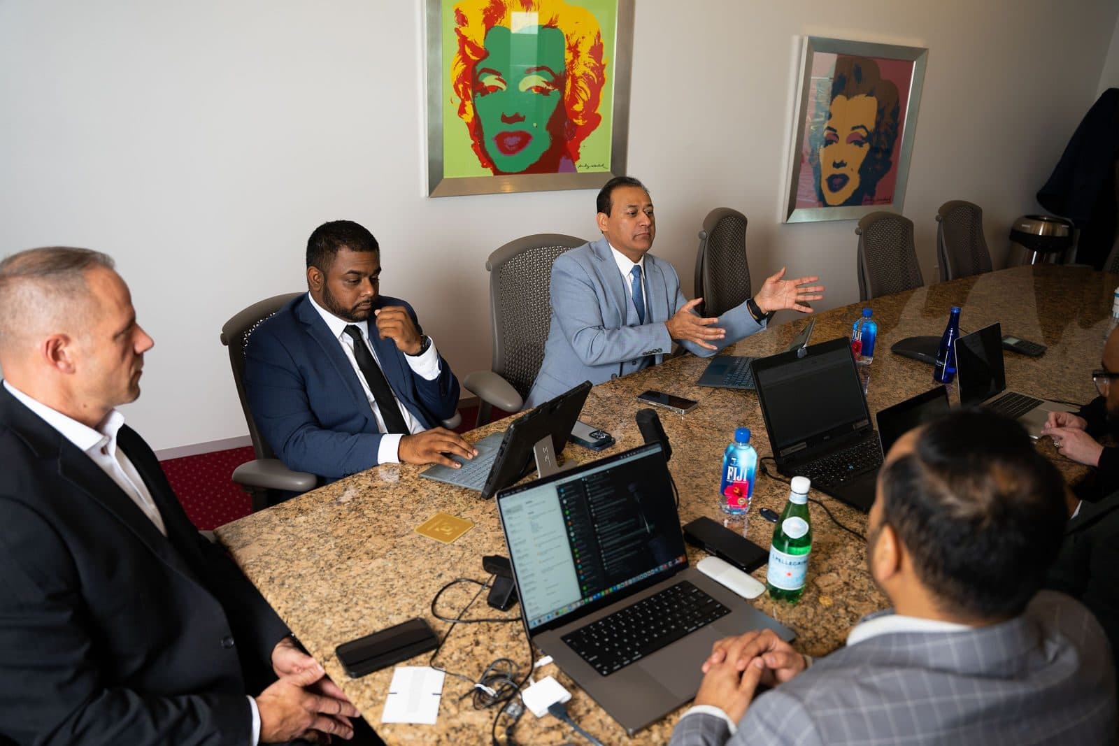 Team meeting around a boardroom table with laptops