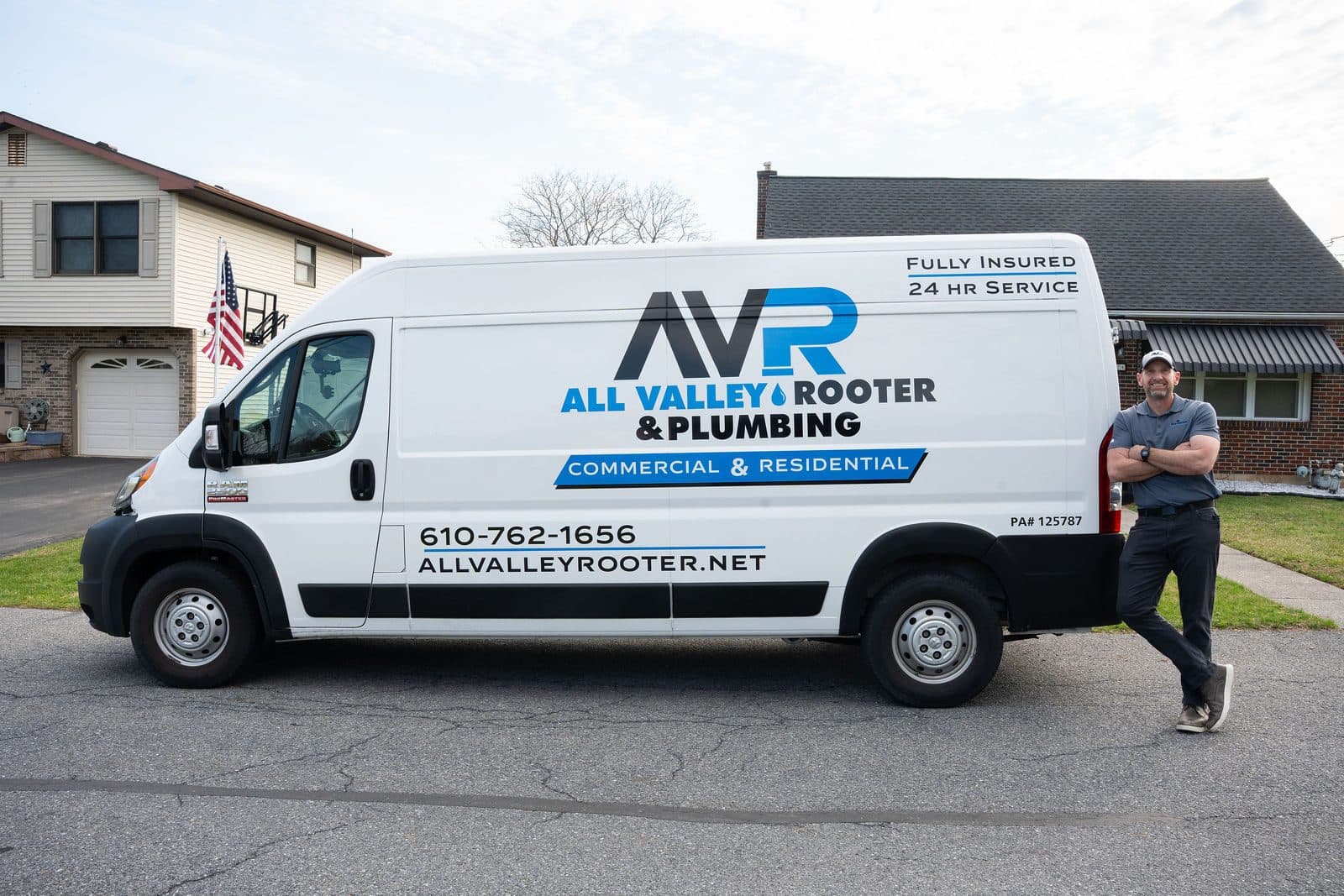 Wide shot of the All Valley Rooter van parked on a residential street