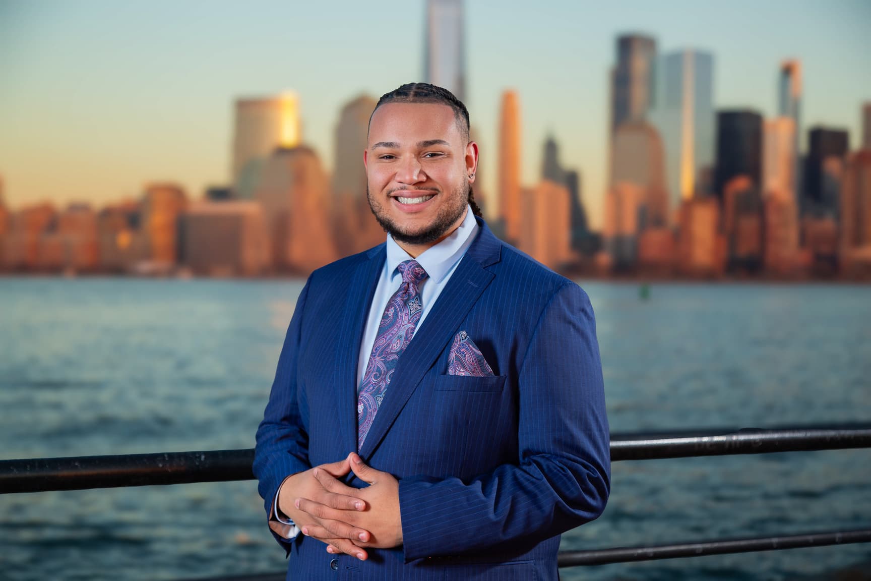 Carter McKinney standing along the waterfront with the New York City skyline behind him
